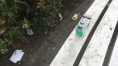 leere Flachmänner abgestellt auf einer Bank