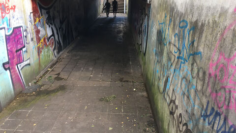 mit Graffitis besprühte, dunkle Unterführung
