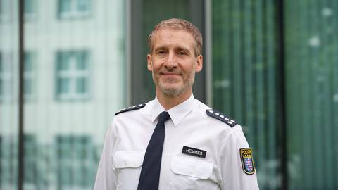 Andreas Hemmes in weißer Uniform vor einem Gebäude