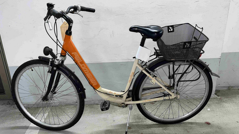 Ein weiß-orange-farbenes Damenrad der Marke "Feldmeier" mit einem Korb auf dem Gepäckträger