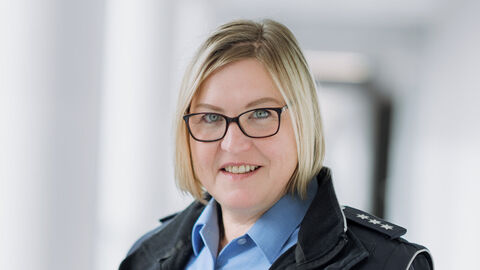 Jana Kaiser in blauem Uniformhemd, dunkler Jacke und hellem Hintergrund