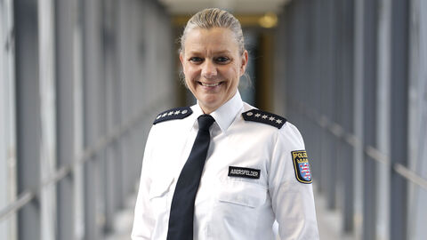 Polizistin in weißem Uniformhemd in einem langen Glasdurchgang