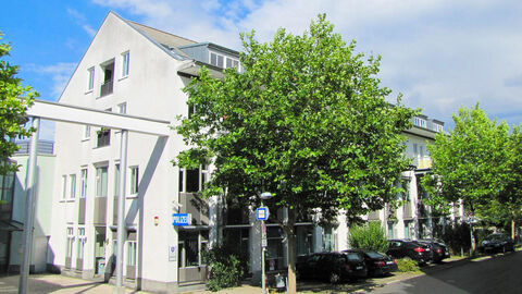 Polizeidirektion Kassel; Foto zeigt das Liegenschaftsgebäude der Polizeidirektion mit Begrünung im Vordergrund bei blauem Himmel