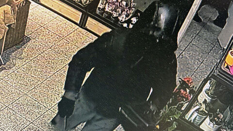 Foto des unbekannten Täters nach bewaffneten Raubüberfall auf Lebensmittelmarkt in Kassel-Waldau; Foto zeigt den Täter von schräg oben und einem Messer in der linken Hand im Kassenbereich, bekleidet mit schwarzer Daunenjacke mit Kapuze, einer graue Hose und schwarzen Turnschuhe