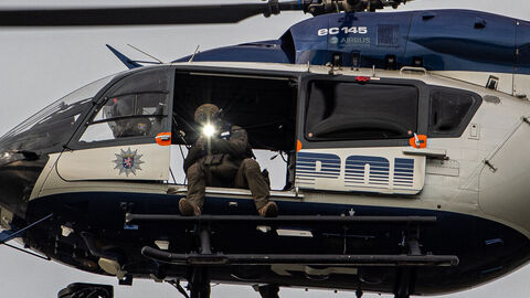 Ein Beamter des Spezialeinsatzkommando sitzt in der Polizeihubschraubertür