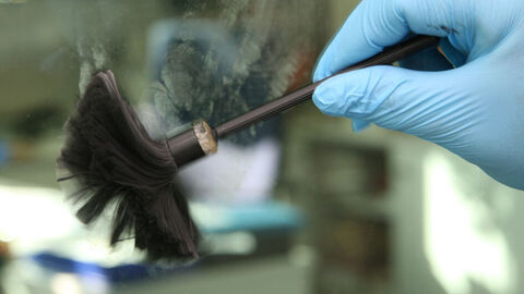 Spurensicherung mit blauen Handschuen an vwerden Fingerabdrücke mit em Pinsel sichtbar gemacht