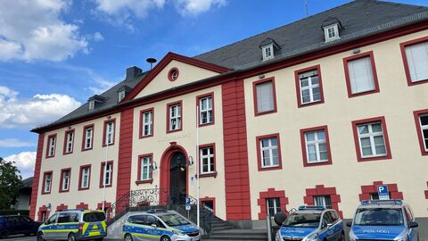 Gebäude der Polizeistation in Usingen mit parkenden Polizeiautos davor.