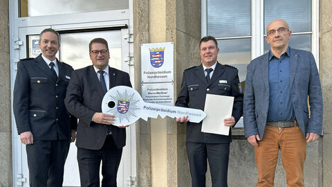 Neue Leitung bei der Polizeistation Eschwege: Auf dem Foto stehen von links Christopher Pfaff, Marco Bärtl, Michael Söder und Rainer Neusüß vor dem Gebäudeeingang der Polizeistation, Marco Bärtl und Michael Söder halten einen symbolischen Schlüssel mit Polizeistern und dem Schriftzug Polizeipräsidium Nordhessen