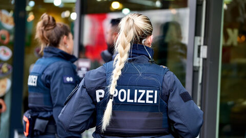 2 uniformierte Polizeibeamtinnen im Einsatz, Ansicht von hinten