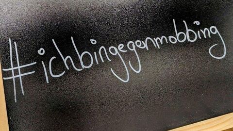 Weißer Schriftzug "Ich bin gegen Mobbing" auf schwarzer Tafel