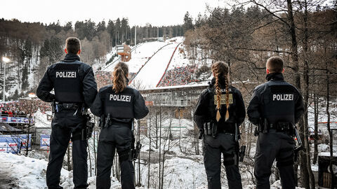 Polizei gut vorbereitet auf FIS Skisprung Weltcup in Willingen; Mehrere Polizeikräfte stehen mit Blick in Richtung Skisprungschanze