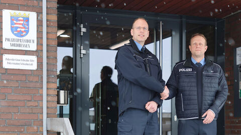 Neuer Schutzmann vor Ort bei der Polizeistation Schwalmstadt; Zwei mannliche Personen stehen auf einem Treppenaufgang zu einem Gebäude und reichen sich die Hand