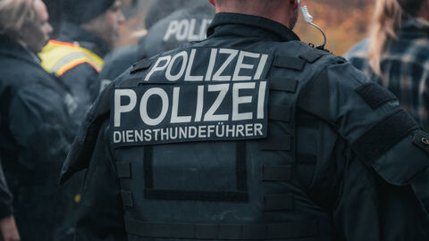 Einsatzkraft von hinten mit Aufschrift "Diensthundeführer" auf Rücken