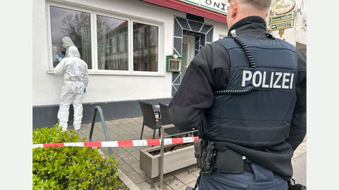 Tatortgruppe mit Polizeibeamten vor Bistro