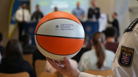 Ein Basketball wird durch einen Polizeibeamten gehalten.