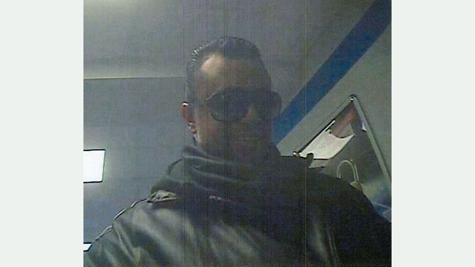 Unbekannter Täter steht an einem Geldautomaten - Frontansicht